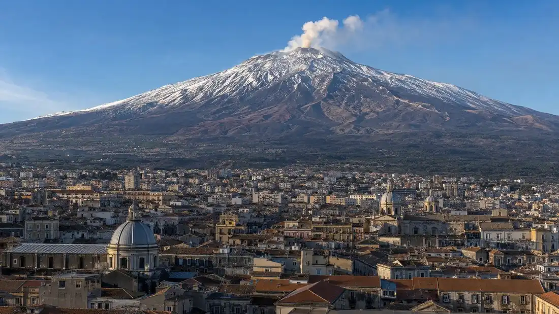 Zasnezena Etna nad strechami Catanie