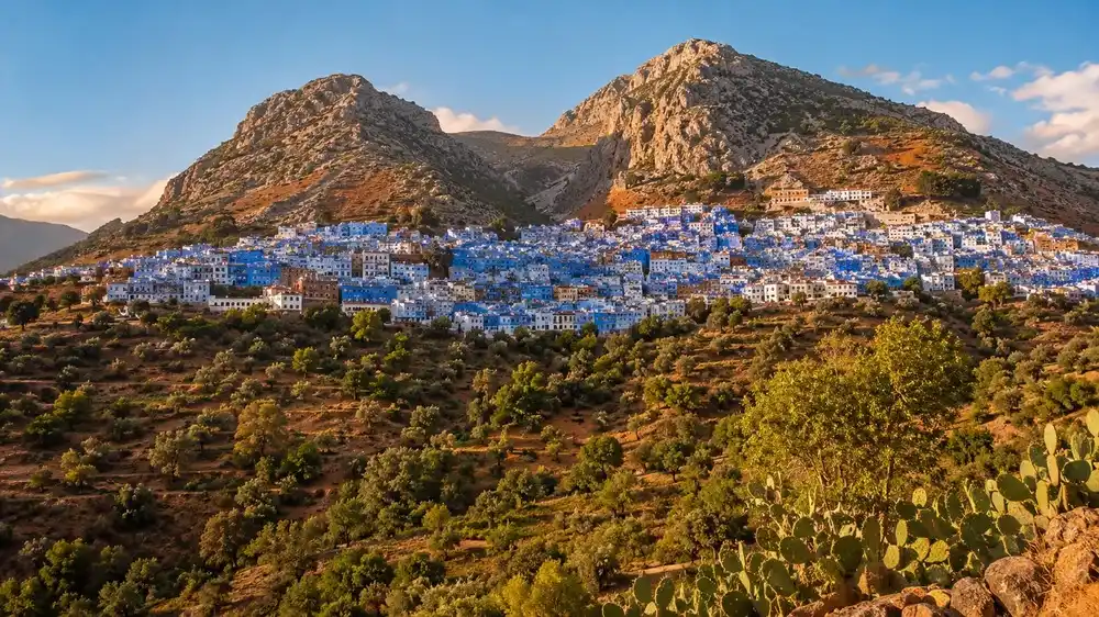 Modre mesto Chefchaouen na svahu pod dvema skalnimi vrcholy z protejsiho kopce
